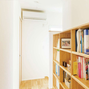 夫婦とも仕事の本など多く持つため、2階ホールに本棚を造り付け。<br>
夏は奥にあるエアコン1台で、冬は1階にあるオイルヒーター1台で暮らせる