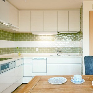 できるだけリビングを広く確保するために、キッチンを壁付けのL字型に。<br>奥さまお気に入りのタイルが空間に彩りを添える