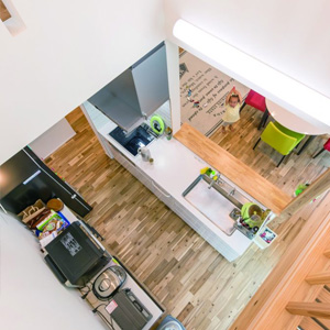 リビングやダイニングではなく、キッチンの真上を吹抜けにした個性的なデザイン。南面の高窓から柔らかな光が降り注ぎ、気持ちよく料理ができる