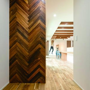 玄関ホールにしつらえたヘリンボーン貼りのアクセントウォールが“間”をつくってくれる